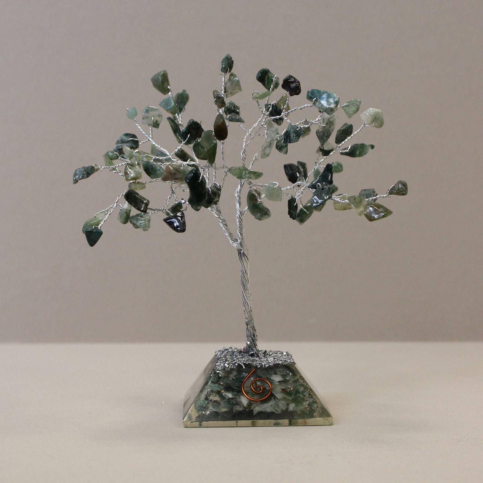 Apportez une touche naturelle et spirituelle à votre intérieur avec cet arbre en agate mousse avec socle en orgonite. Composé de 80 pierres naturelles, il séduit par son allure élégante, son esthétique minérale et sa présence décorative apaisante.
