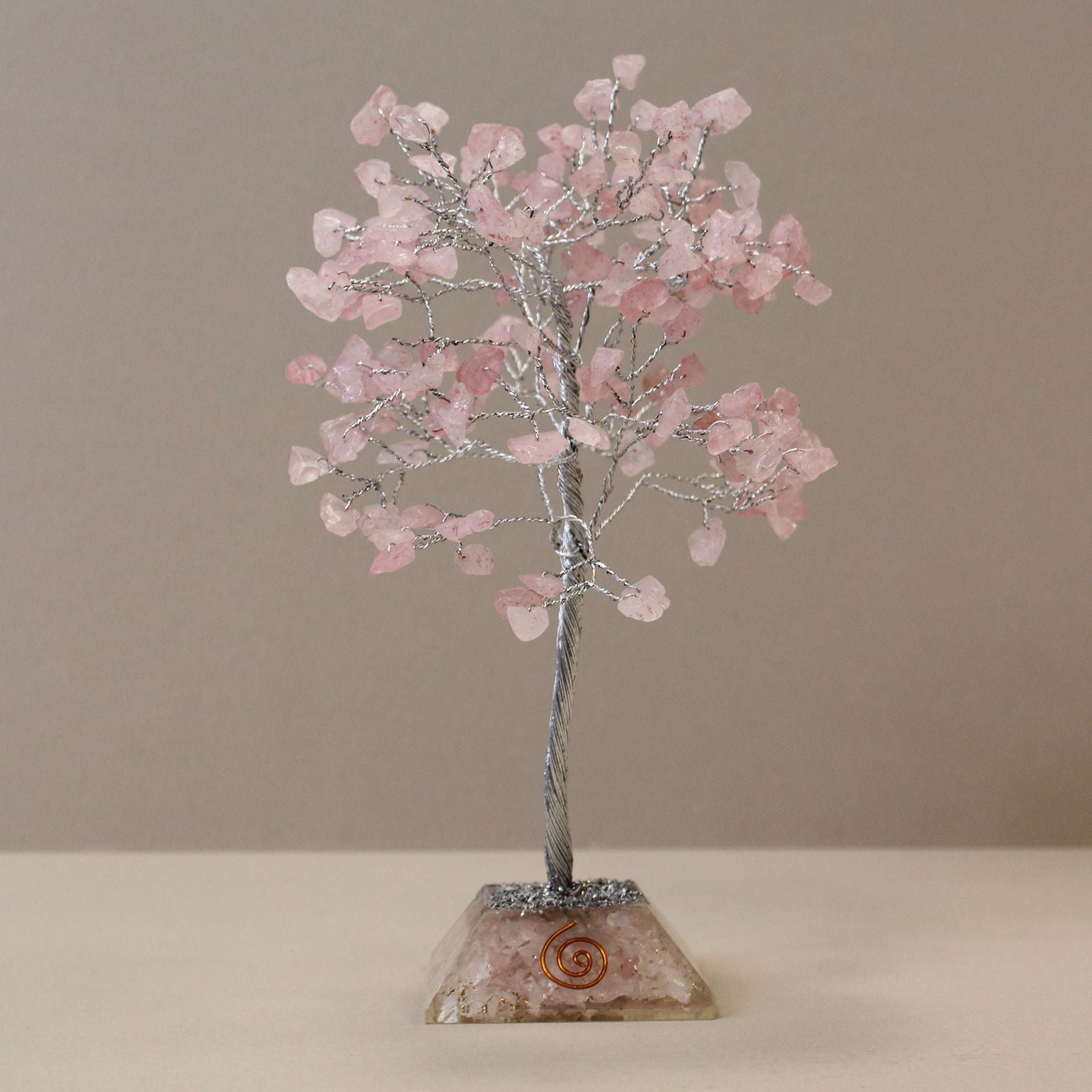 Apportez une touche douce et spirituelle à votre intérieur avec cet arbre en quartz rose avec socle en orgonite. Composé de 160 pierres naturelles, il séduit par son allure généreuse, son esthétique minérale et sa présence décorative apaisante.