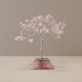 Apportez une touche douce et spirituelle à votre intérieur avec cet arbre en quartz rose avec socle en orgonite. Composé de 80 pierres naturelles, il séduit par son allure élégante, son esthétique minérale et son univers apaisant.