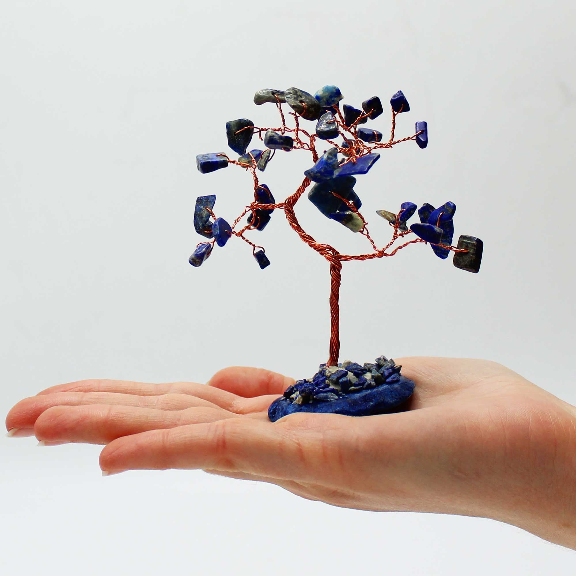 Apportez une touche minérale et harmonieuse à votre intérieur avec cet arbre en sodalite sur socle en agate bleue. Orné de 35 pierres naturelles, il séduit par son format élégant, son style artisanal et son esthétique spirituelle.