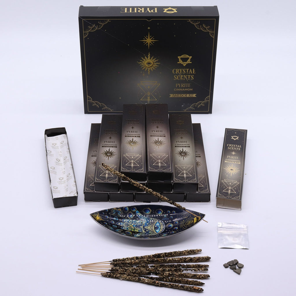Encens Smudge Cannelle accompagné d’éclats de Pyrite naturelle. La boîte contient 10 bâtons d’environ 20 cm, fabriqués à la main en Inde et présentés dans un étui cartonné sombre au thème céleste.