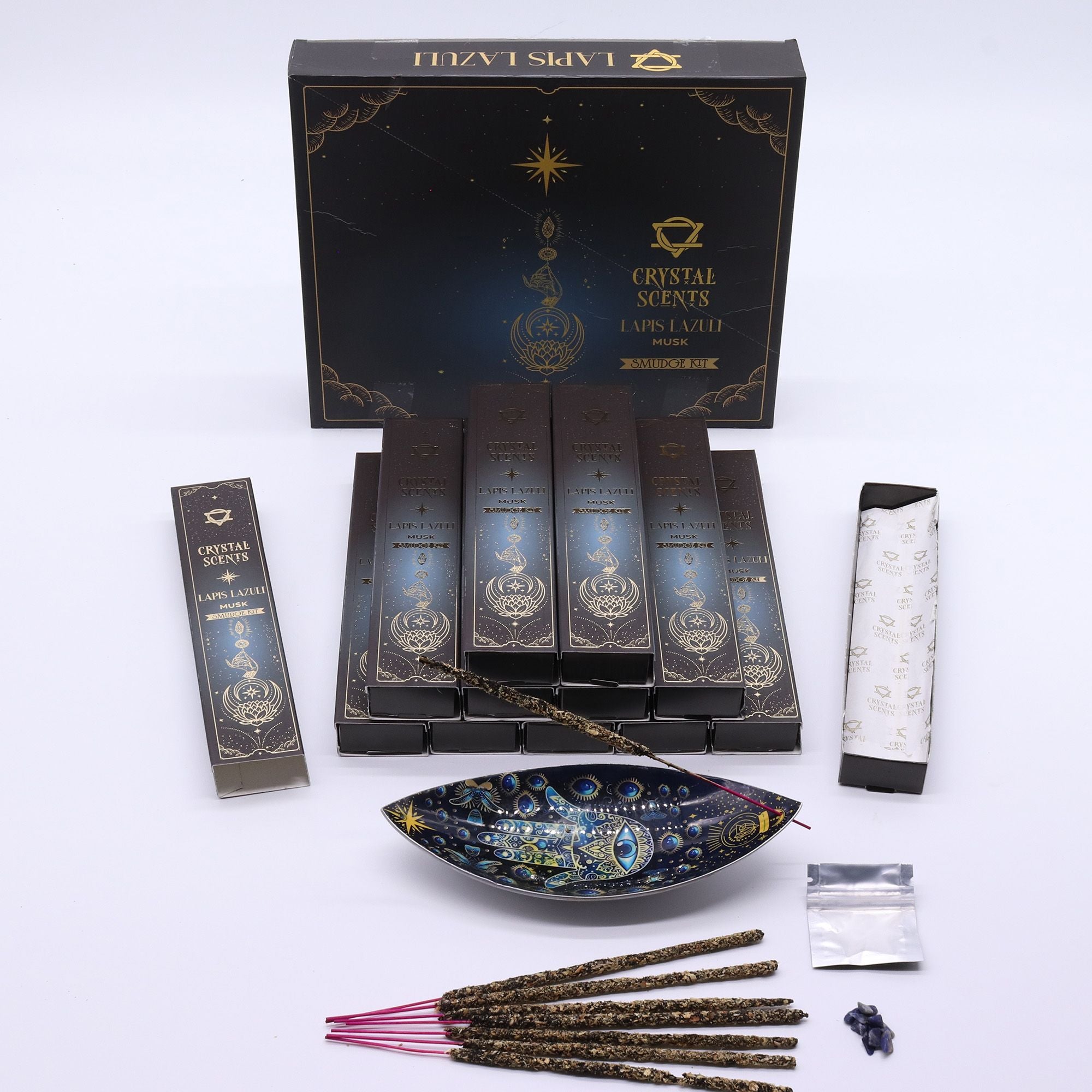 Encens Smudge Musc accompagné d’éclats de Lapis Lazuli naturel. La boîte contient 10 bâtons d’environ 20 cm, fabriqués à la main en Inde et présentés dans un étui cartonné inspiré du ciel nocturne.