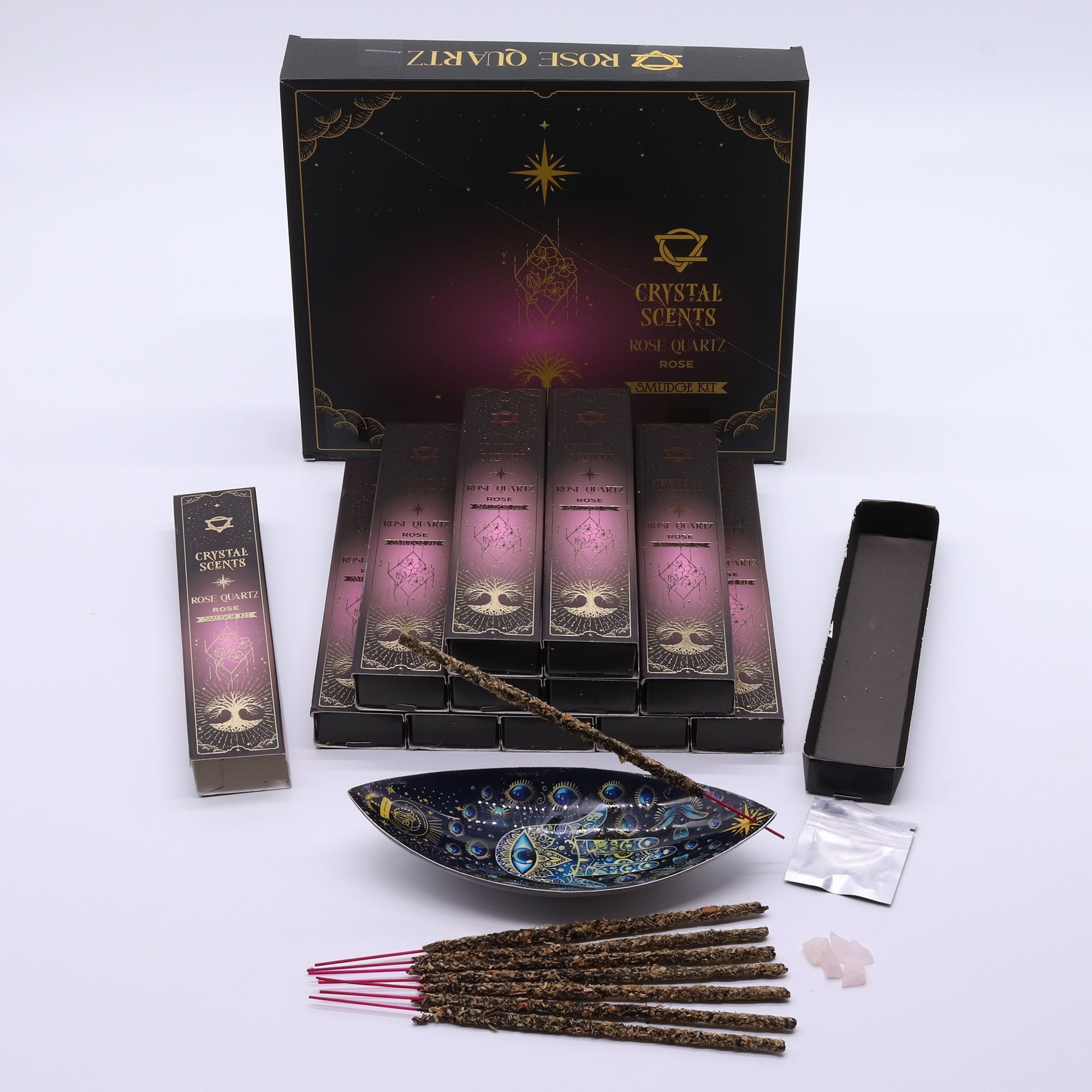 Encens Smudge Rose accompagné d’éclats de Quartz Rose naturel. La boîte contient 10 bâtons d’environ 20 cm, fabriqués en Inde et présentés dans un étui cartonné au dégradé rose.