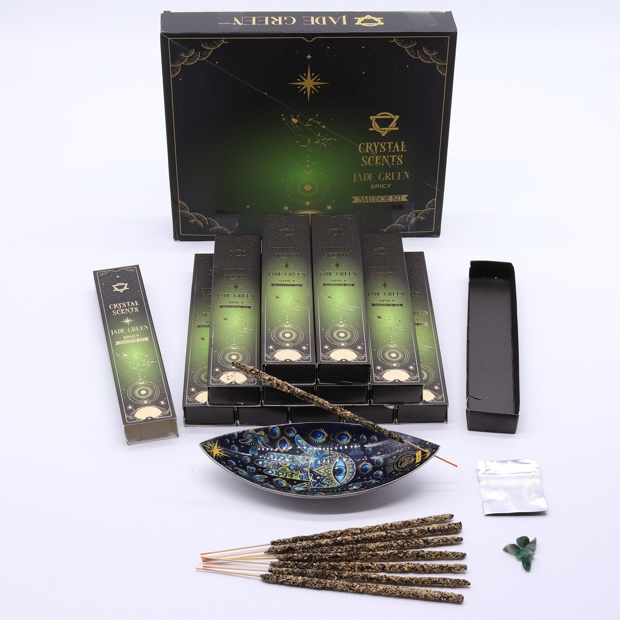 Encens Smudge Épicé accompagné d’éclats de Jade naturel. La boîte contient 10 bâtons d’environ 20 cm, fabriqués à la main en Inde et présentés dans un étui cartonné vert au thème céleste.
