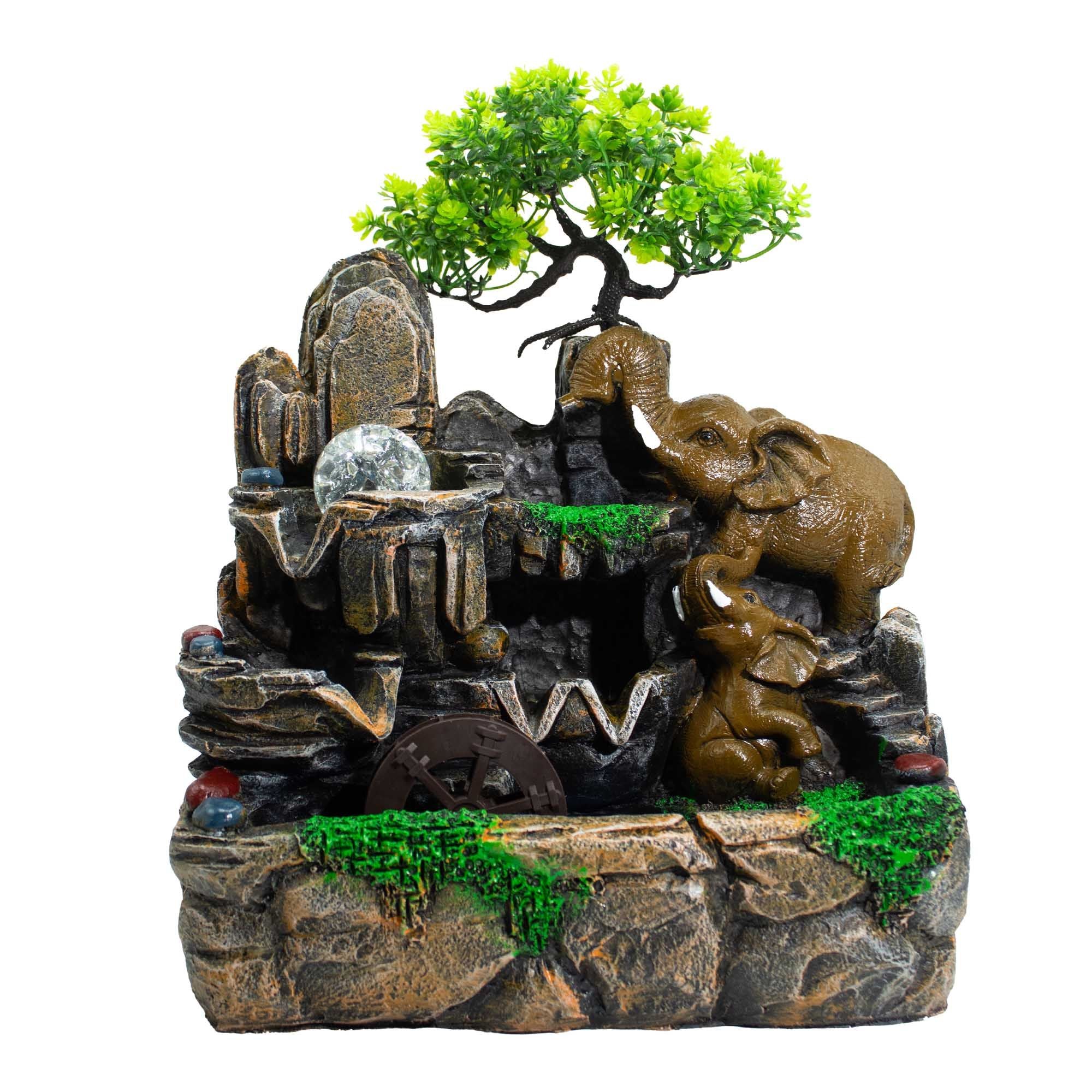 Apportez douceur et sérénité à votre intérieur avec cette fontaine de table de 35 cm représentant deux éléphants face à face sous un arbre stylisé. Avec sa boule cristal, sa lumière douce et son moulin à eau, elle crée une ambiance zen, chaleureuse et décorative.