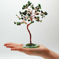 Apportez une touche minérale et apaisante à votre intérieur avec ce grand arbre en aventurine verte sur socle en agate verte. Orné de 100 pierres naturelles, il séduit par son allure élégante, son style artisanal et son esthétique spirituelle.