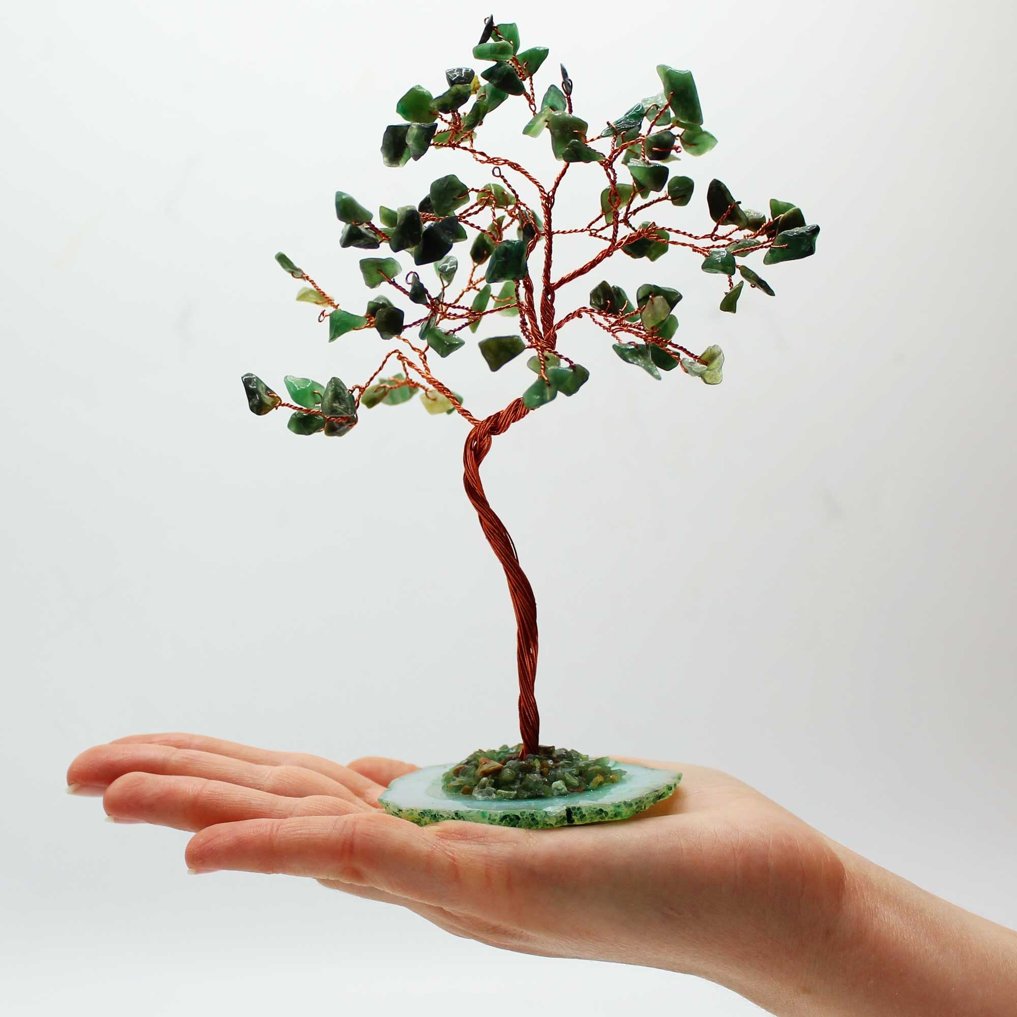 Apportez une touche minérale et apaisante à votre intérieur avec ce grand arbre en aventurine verte sur socle en agate verte. Orné de 100 pierres naturelles, il séduit par son allure élégante, son style artisanal et son esthétique spirituelle.