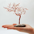 Apportez une présence minérale forte et lumineuse à votre intérieur avec ce grand arbre en cristal de roche sur socle en agate noire. Orné de 100 pierres naturelles, il séduit par son allure élégante, son style artisanal et son esthétique spirituelle.