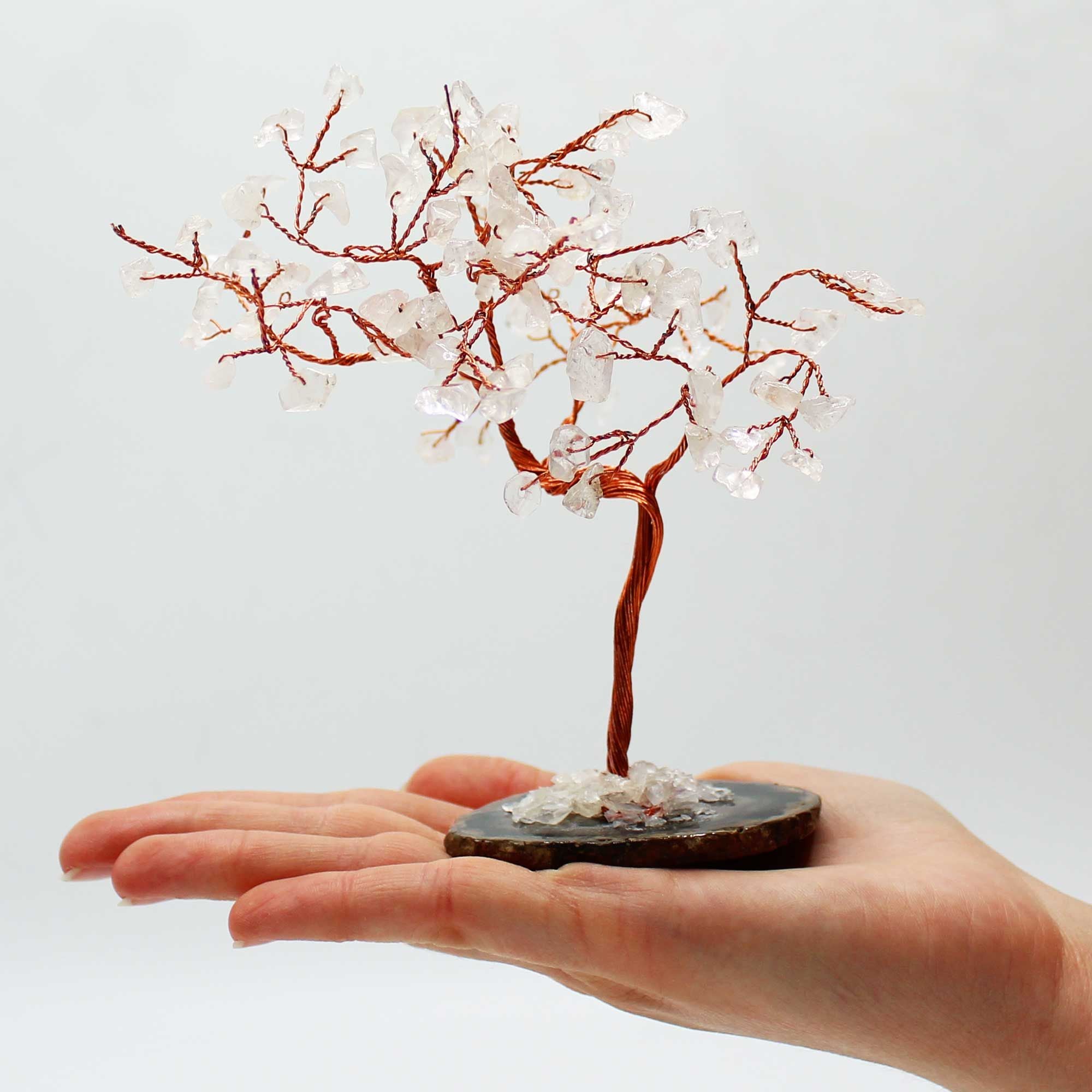 Apportez une présence minérale forte et lumineuse à votre intérieur avec ce grand arbre en cristal de roche sur socle en agate noire. Orné de 100 pierres naturelles, il séduit par son allure élégante, son style artisanal et son esthétique spirituelle.