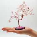 Apportez une touche douce et lumineuse à votre intérieur avec ce grand arbre en quartz rose sur socle en agate rose. Orné de 100 pierres naturelles, il séduit par son allure élégante, son style artisanal et son esthétique spirituelle.