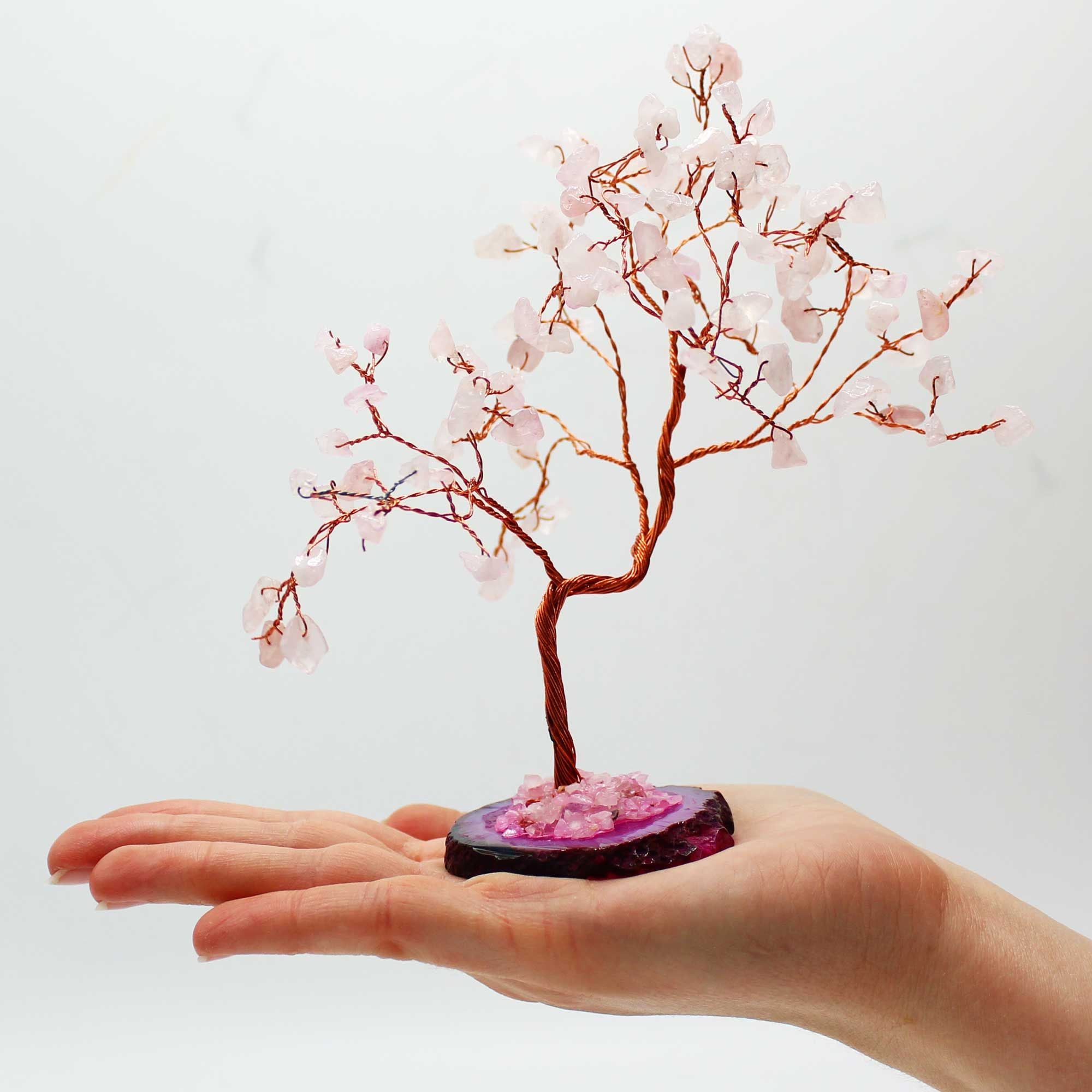 Apportez une touche douce et lumineuse à votre intérieur avec ce grand arbre en quartz rose sur socle en agate rose. Orné de 100 pierres naturelles, il séduit par son allure élégante, son style artisanal et son esthétique spirituelle.