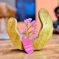 Apportez une touche douce et spirituelle à votre intérieur avec ce jardin arbre en quartz rose. Composé de 60 éclats de pierre naturelle et présenté dans un anneau ouvert en bois de manguier, il crée une ambiance harmonieuse, apaisante et pleine de charme.
