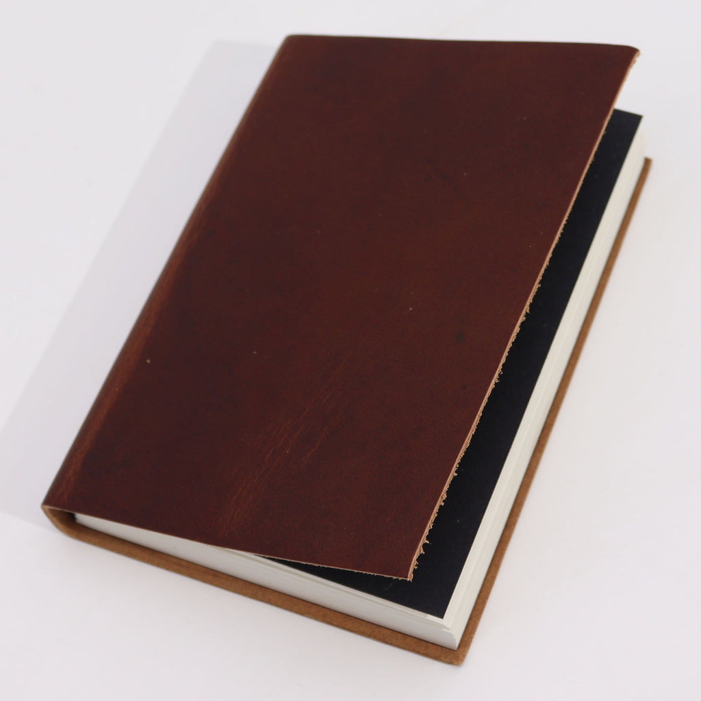Journal/grimoire en cuir brun foncé avec 100 pages lignées en papier. Son format compact de 18 x 13 cm en fait un carnet pratique pour l’écriture, les notes et les idées du quotidien.