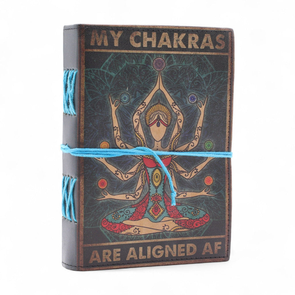 Journal/grimoire en cuir imprimé avec motif Chakras et texte “My Chakras Are Aligned AF”. Il contient 200 pages blanches en papier, idéales pour écrire, dessiner ou noter ses inspirations.