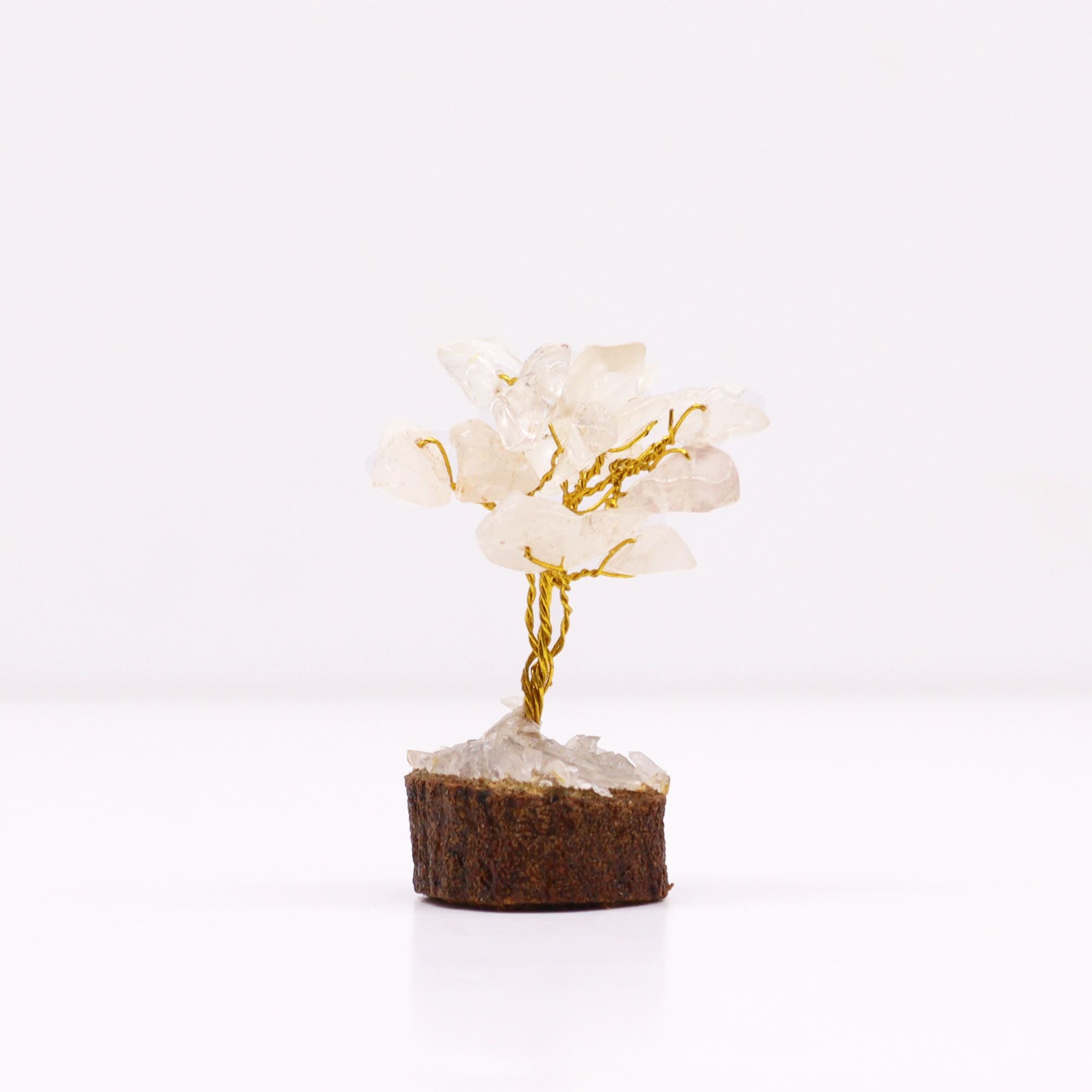 Apportez une touche minérale et lumineuse à votre intérieur avec ce mini arbre en cristal de roche sur socle en bois. Orné de 15 pierres de cristal de roche, il séduit par son petit format, son style artisanal et son esthétique spirituelle.