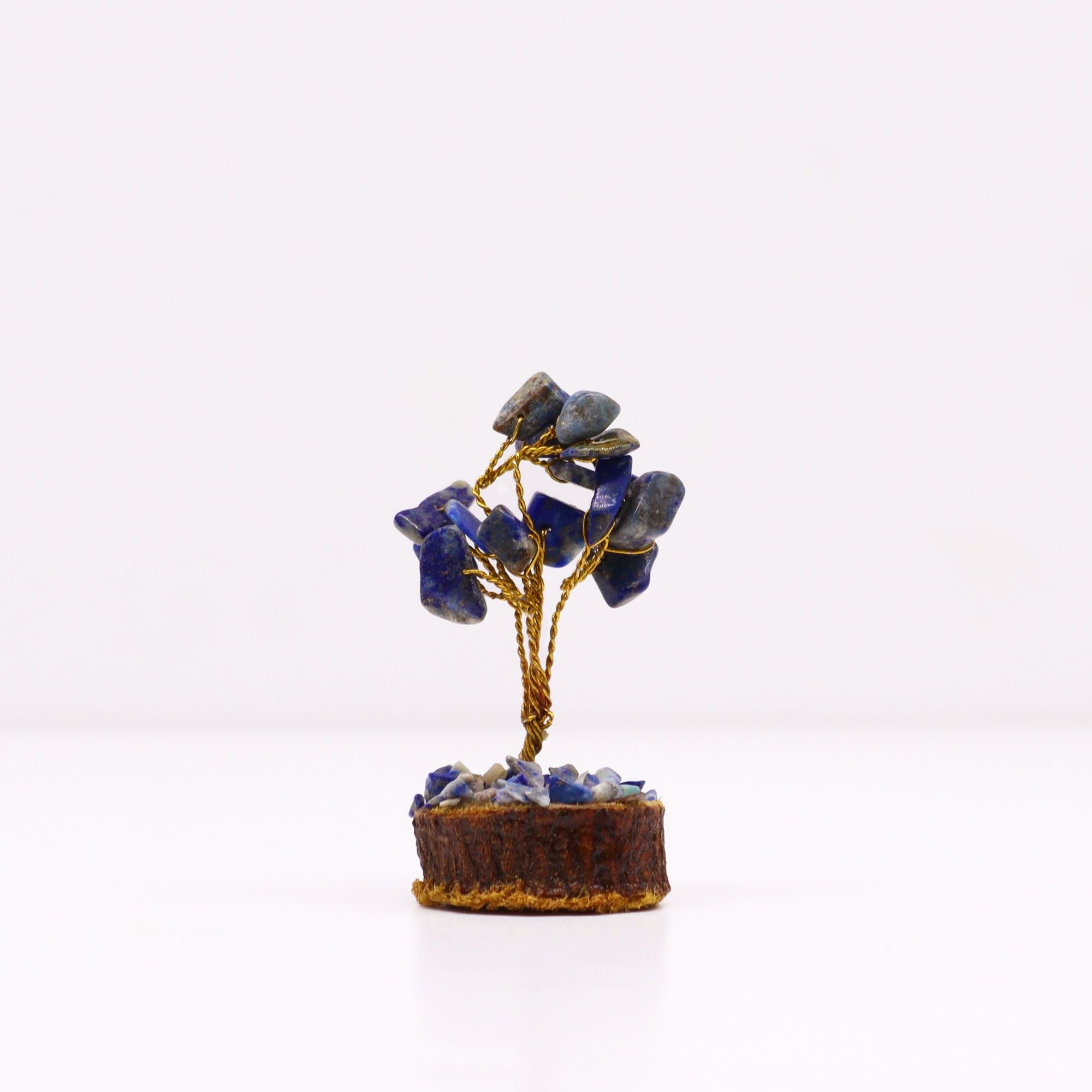 Apportez une touche minérale et spirituelle à votre intérieur avec ce mini arbre en sodalite sur socle en bois. Orné de 15 pierres de sodalite, il séduit par son petit format, son style artisanal et son esthétique symbolique.