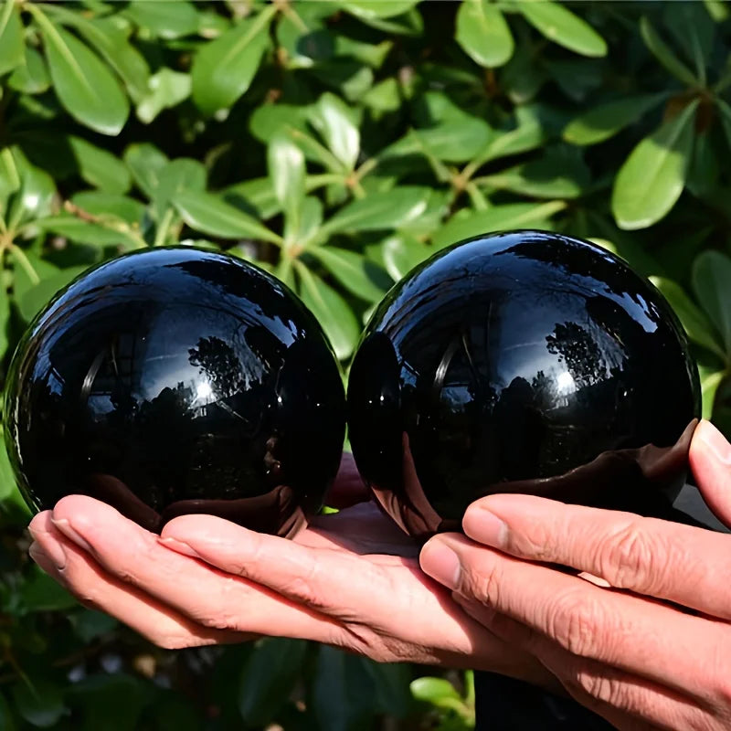 Deux boules en obsidienne noire naturelle polie – de 2 à 13 cm montrées ensemble, parfaites pour enrichir votre décoration feng shui et comme objet spirituel.