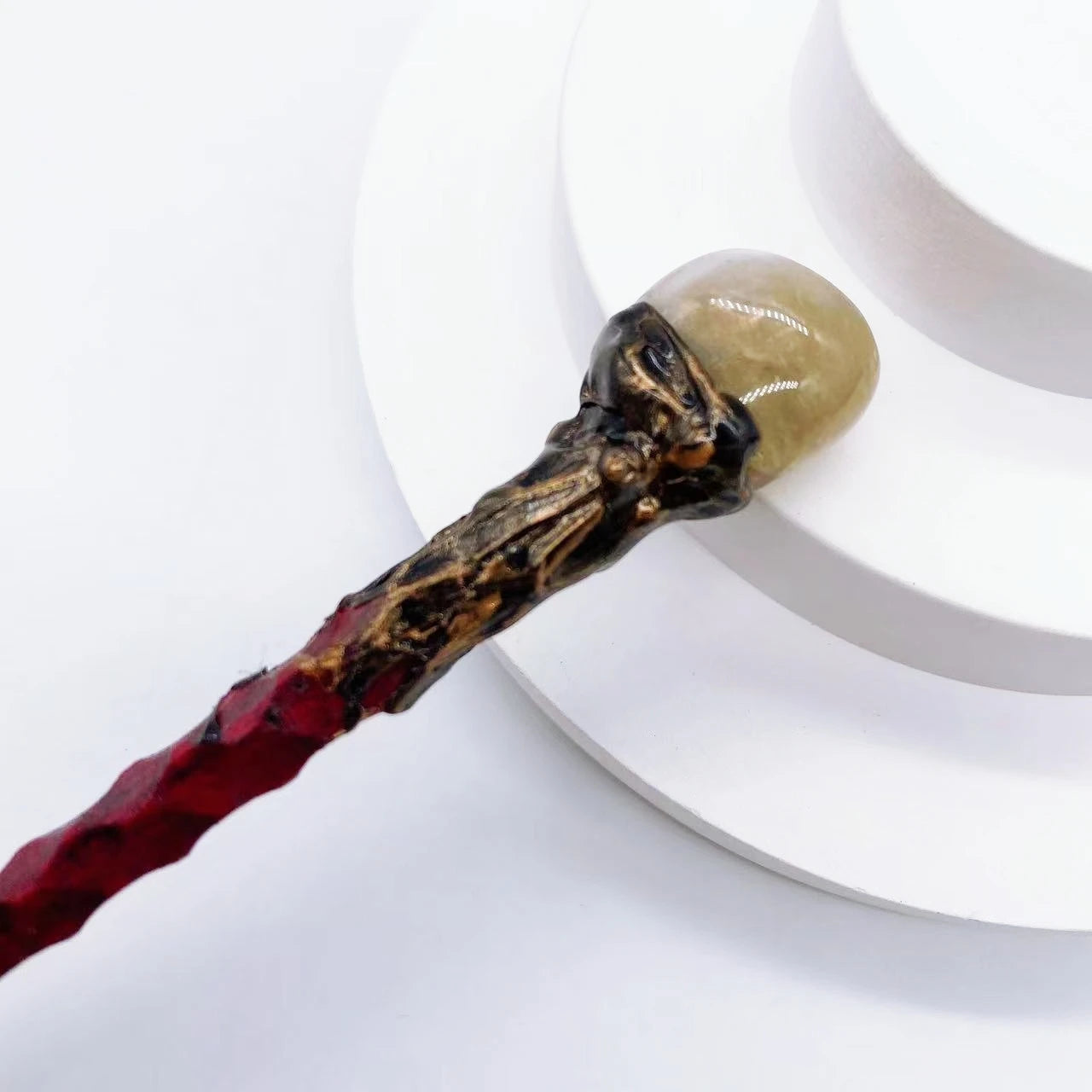 Bâton magique rouge avec une pointe en quartz citrine, proposé par Aemilia Mystica. Pour la décoration intérieure inspirée par la magie.