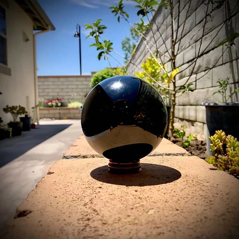 Boule en obsidienne noire naturelle polie – de 2 à 13 cm posée sur un mur, brillamment poli et décoratif, idéale comme boule décorative minérale, pièce en pierre naturelle et symbole spirituel.