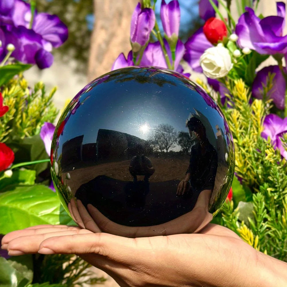 Boule en obsidienne noire naturelle polie – de 2 à 13 cm dans une main, reflet des environs, une belle décoration feng shui et un cadeau pierre naturelle.