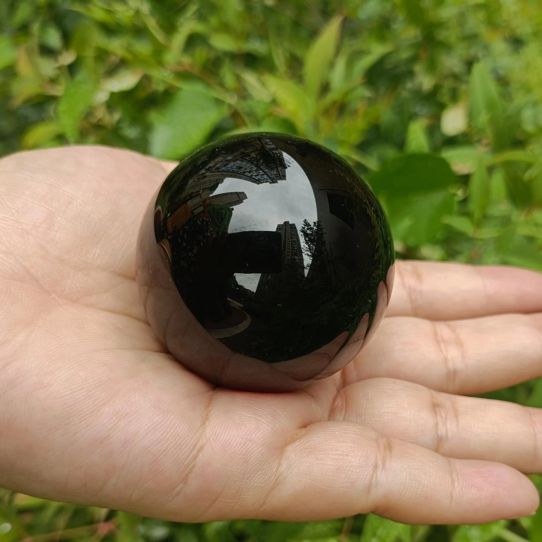 Boule en obsidienne noire naturelle polie – de 2 à 13 cm tenant dans une main, rayonnant de beauté et d'élégance comme une boule décorative minérale.