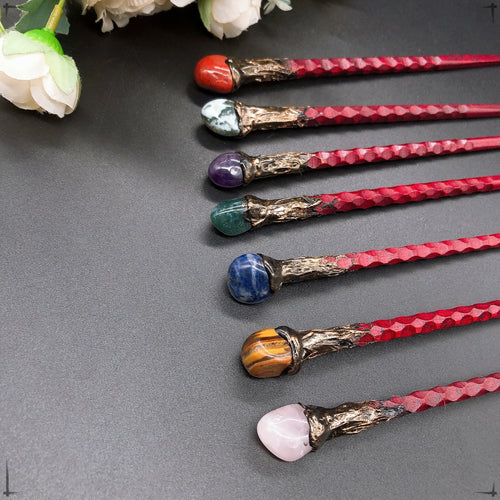 Détails des baguettes magiques avec diverses pierres telles que l'agate rouge et l'améthyste, disponibles chez Aemilia Mystica.