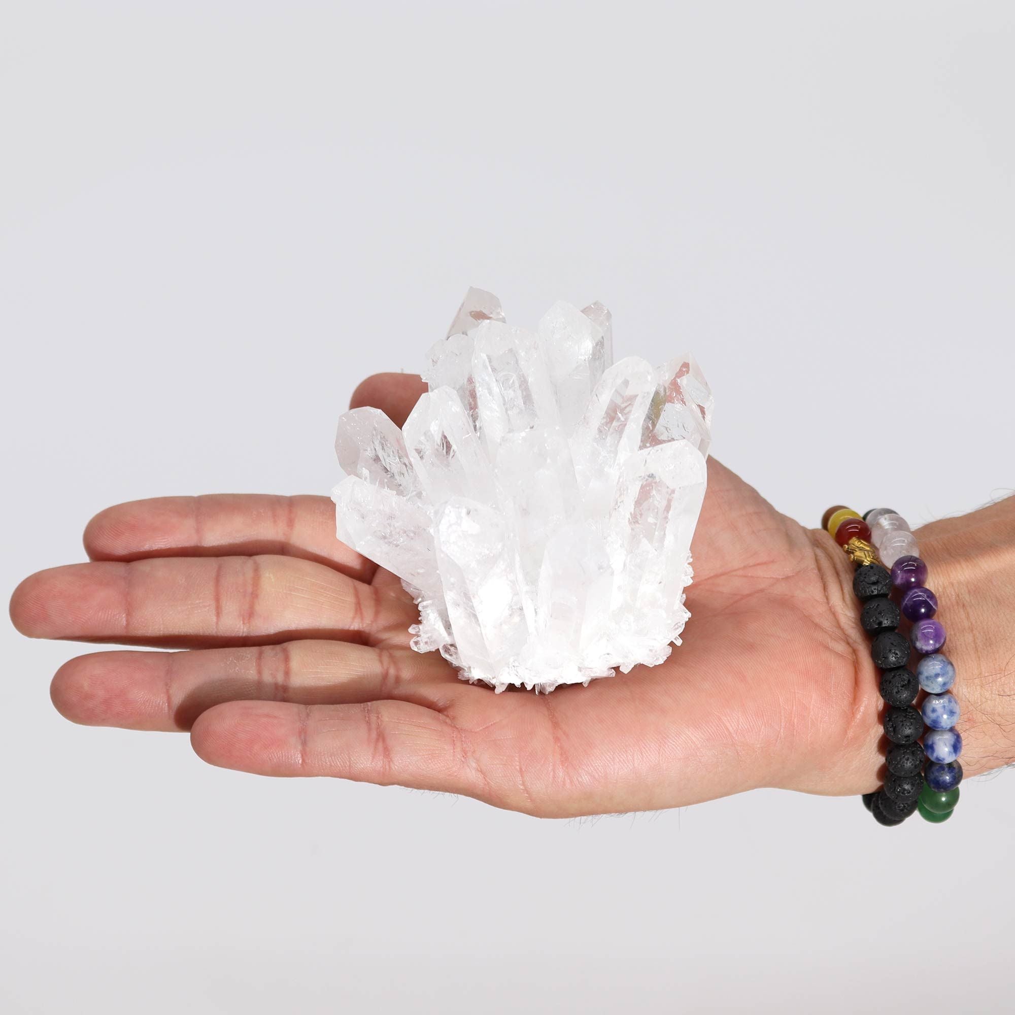 Amas de quartz clair naturel de 8 cm présenté dans une main, mettant en valeur sa luminosité et sa pureté. Produit par AWGifts Dropship.