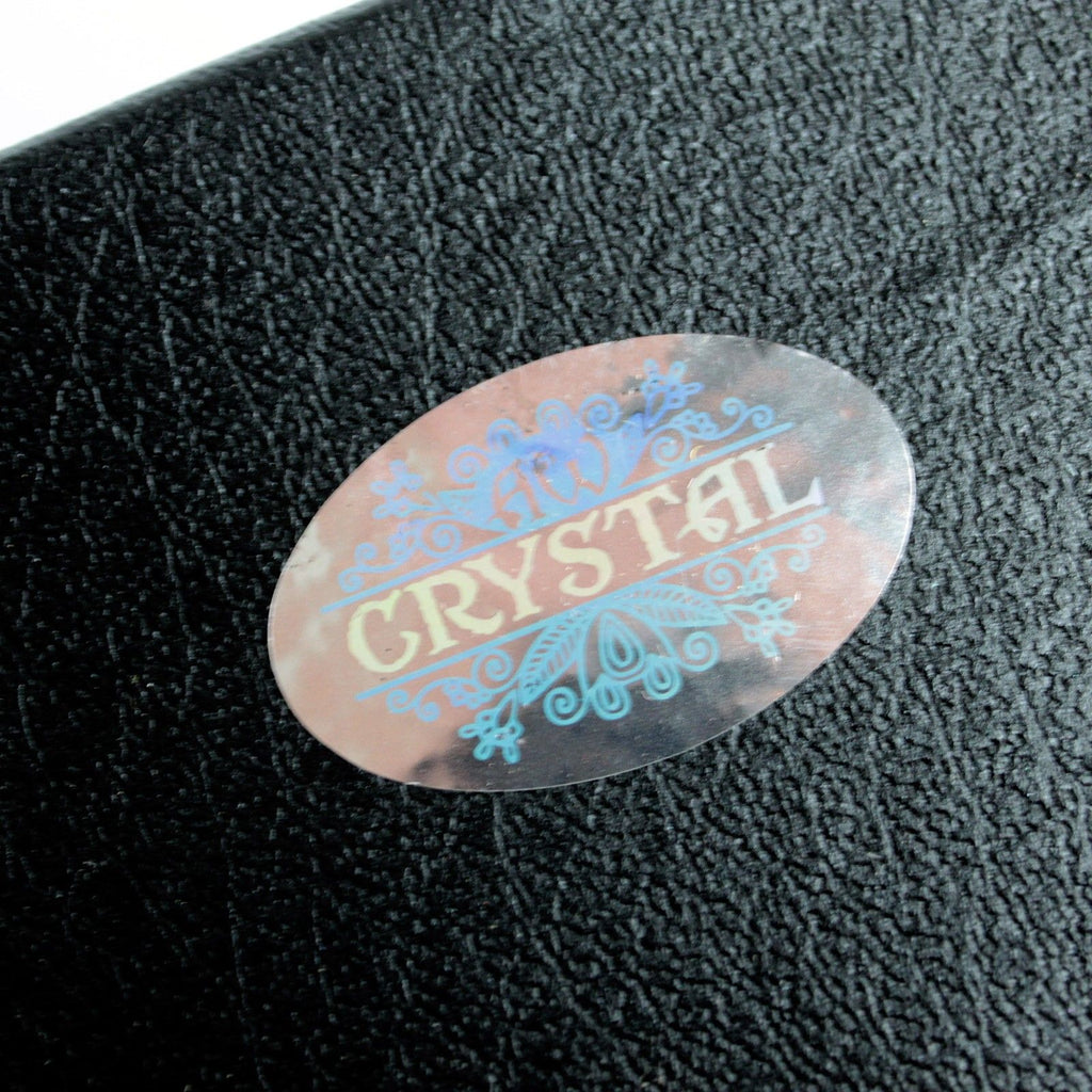 Étiquette d'un produit mettant en avant le texte 'AW Crystal', en rapport avec la boule de cristal sur support de 130 mm, un accessoire spirituel essentiel pour les amateurs de décoration mystique et d'objet symbolique pour autels ésotériques.