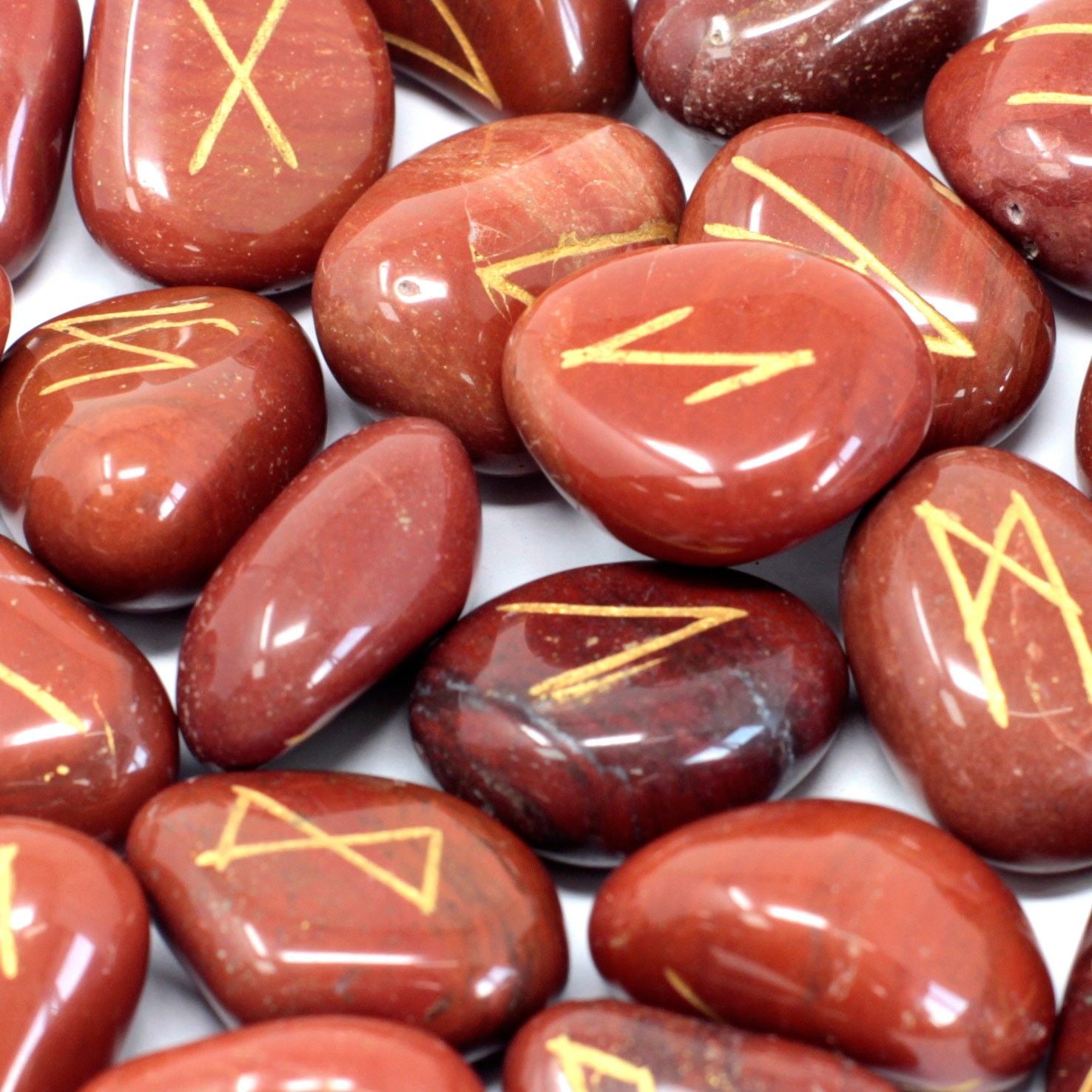 Set de pierres runiques jaspe rouge avec 25 pierres, dont 24 portant des symboles runiques, parfait pour les passionnés du mystique.