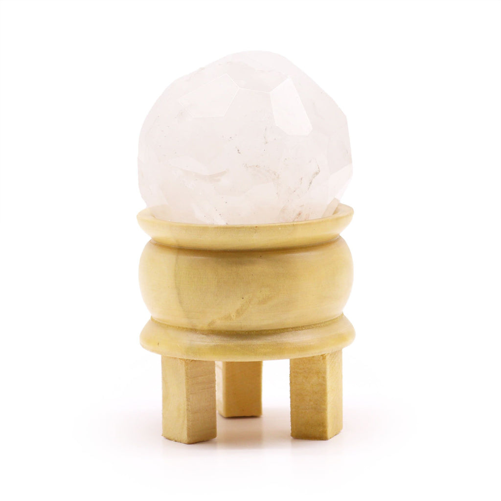 Boule De Guérison En Cristal De Roche sur un support en bois, montrant son éclat en cristal de roche naturel et facetté, convenant à la purification énergétique et à l'harmonisation énergétique, parfait pour enrichir votre déco spirituelle de Aemilia Mystica.