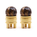 Gemstone Faceted Healing Ball & Stand - Tigereye. Cette sphère en œil de tigre est accompagnée de son support en bois, idéale pour la lithothérapie et la décoration spirituelle. Parfaite pour la protection énergétique et renforcer la confiance en soi, cette boule de guérison en œil de tigre est une pierre naturelle essentielle.