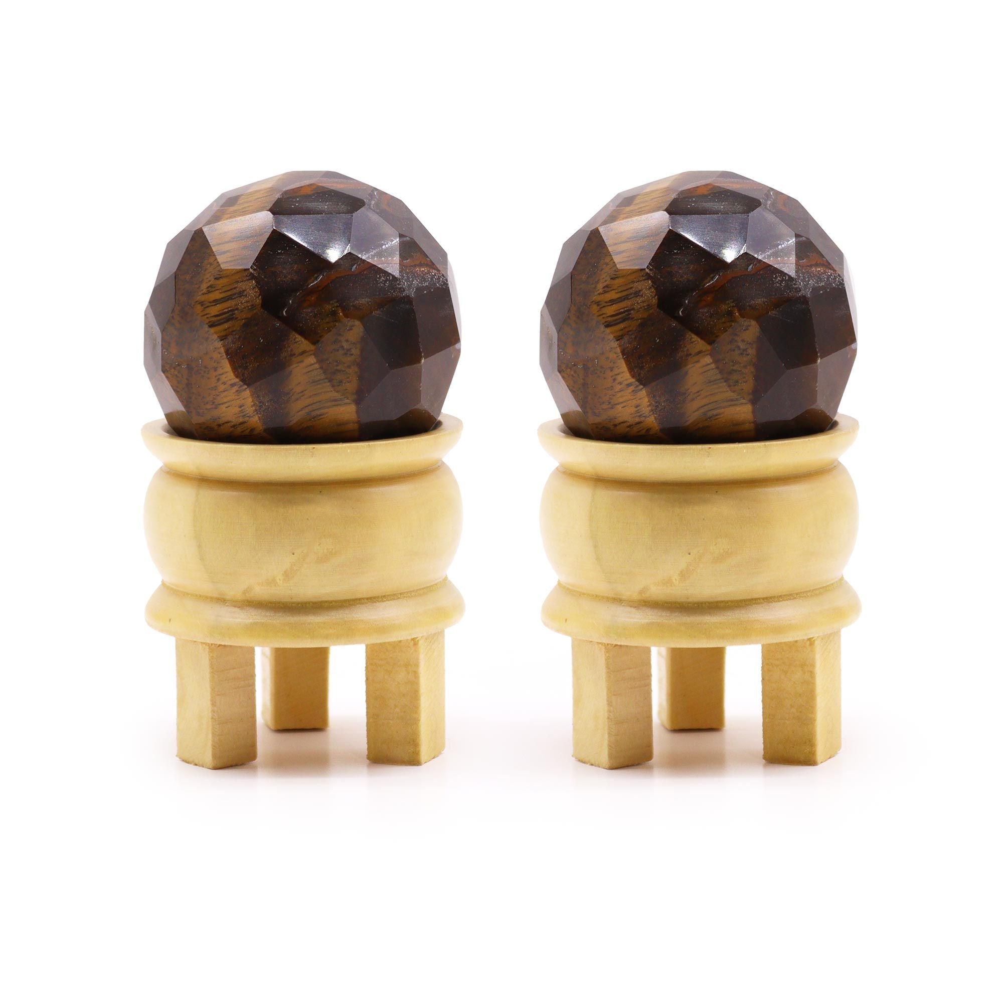 Gemstone Faceted Healing Ball & Stand - Tigereye. Cette sphère en œil de tigre est accompagnée de son support en bois, idéale pour la lithothérapie et la décoration spirituelle. Parfaite pour la protection énergétique et renforcer la confiance en soi, cette boule de guérison en œil de tigre est une pierre naturelle essentielle.