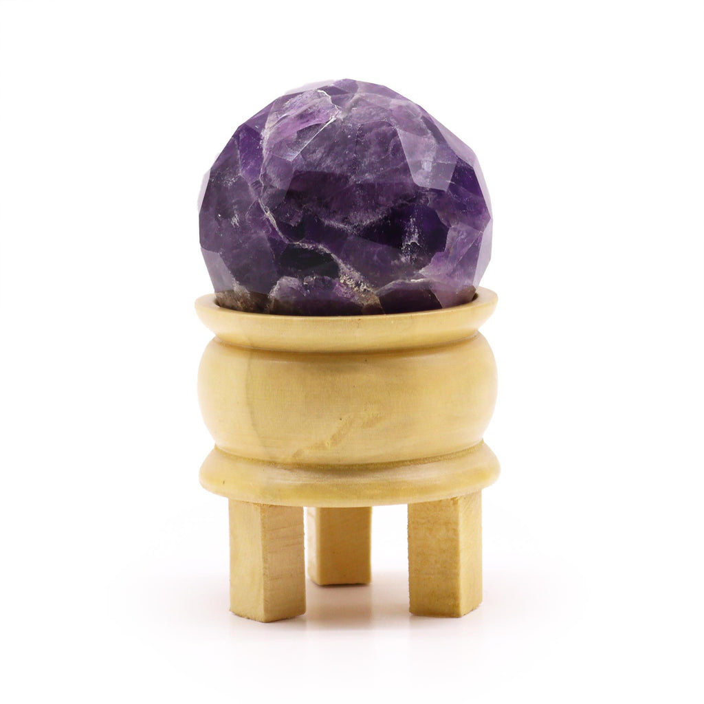 Boule De Guérison En Améthyste Facetée avec support en bois, cette sphère améthyste facettée en améthyste naturelle est parfaite pour la lithothérapie. Son design élégant offre sérénité et intuition lors de la méditation, tout en mettant en valeur le chakra couronne et le troisième œil. Une belle décoration spirituelle pour votre espace de bien-être, de la marque Aemilia Mystica.