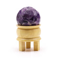 Boule De Guérison En Améthyste Facetée avec support en bois, cette sphère améthyste facettée en améthyste naturelle est parfaite pour la lithothérapie. Son design élégant offre sérénité et intuition lors de la méditation, tout en mettant en valeur le chakra couronne et le troisième œil. Une belle décoration spirituelle pour votre espace de bien-être, de la marque Aemilia Mystica.