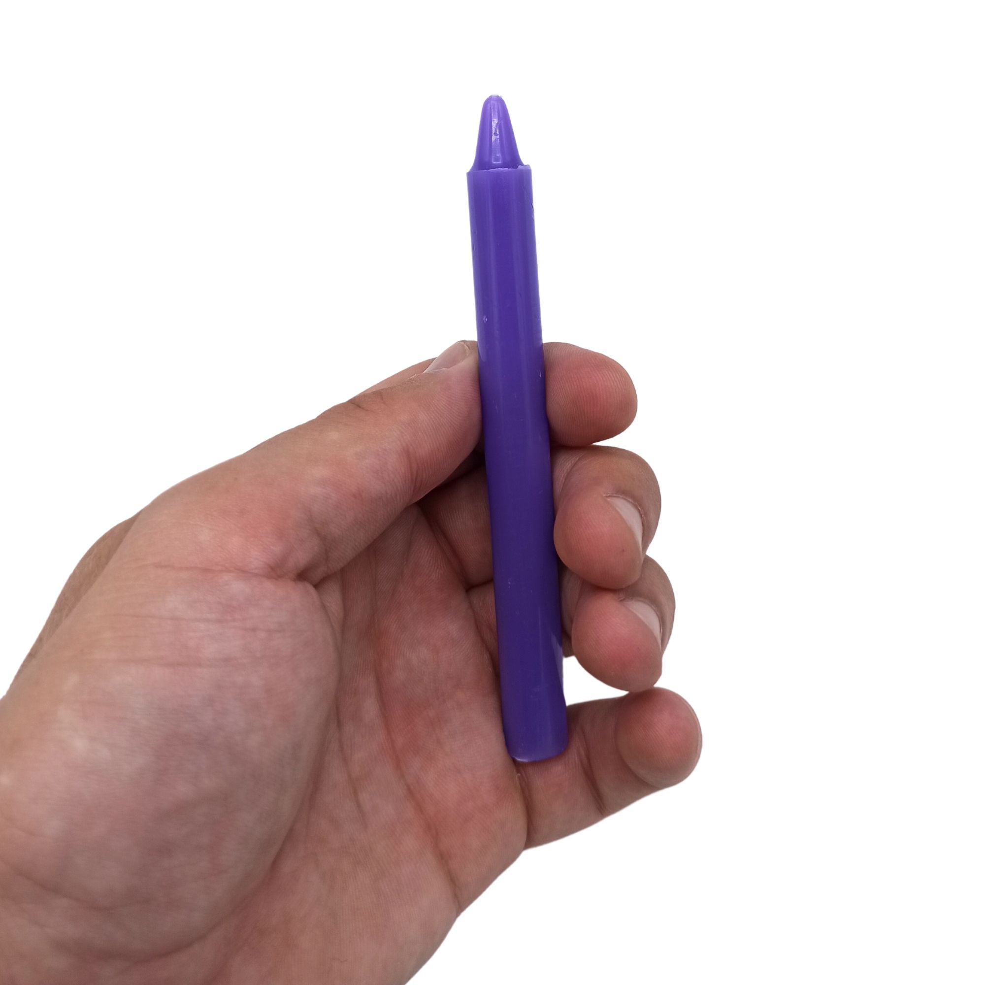 Bougies Manifest Magic (lot de 12) - violet - chakra couronne, vue d'une main tenant une bougie violette. Parfaites pour optimiser vos pratiques spirituelles, elles favorisent la méditation et la sérénité tout en aidant à la transformation intérieure.