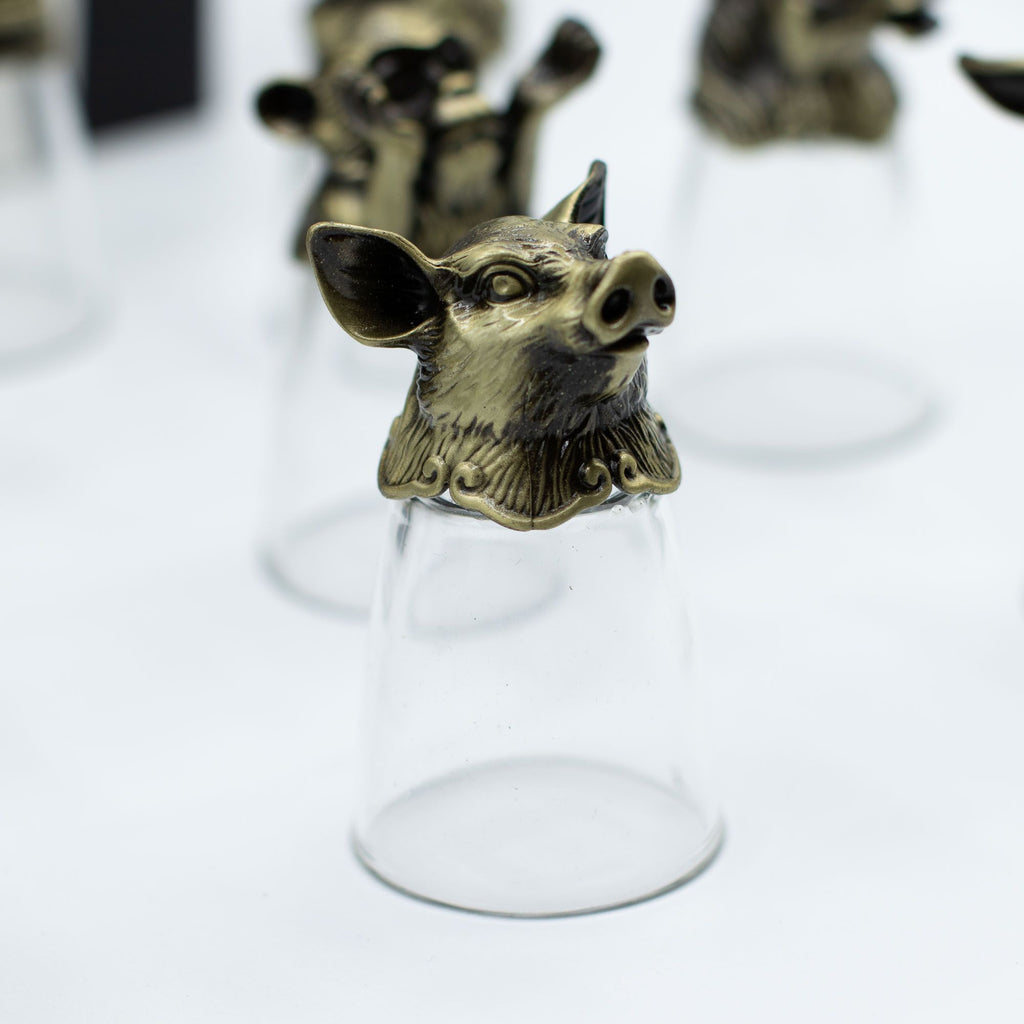Un verre à shot en bronze antique illustrant un cochon, partie du lot de 12 Bottom Up Shot Glasses (25ml). Idéal pour les accessoires de bar, ce verres à shot de 25 ml combine praticité et éléments du zodiaque chinois. Un coffret cadeau unique qui séduira les amateurs d'arts de la table.