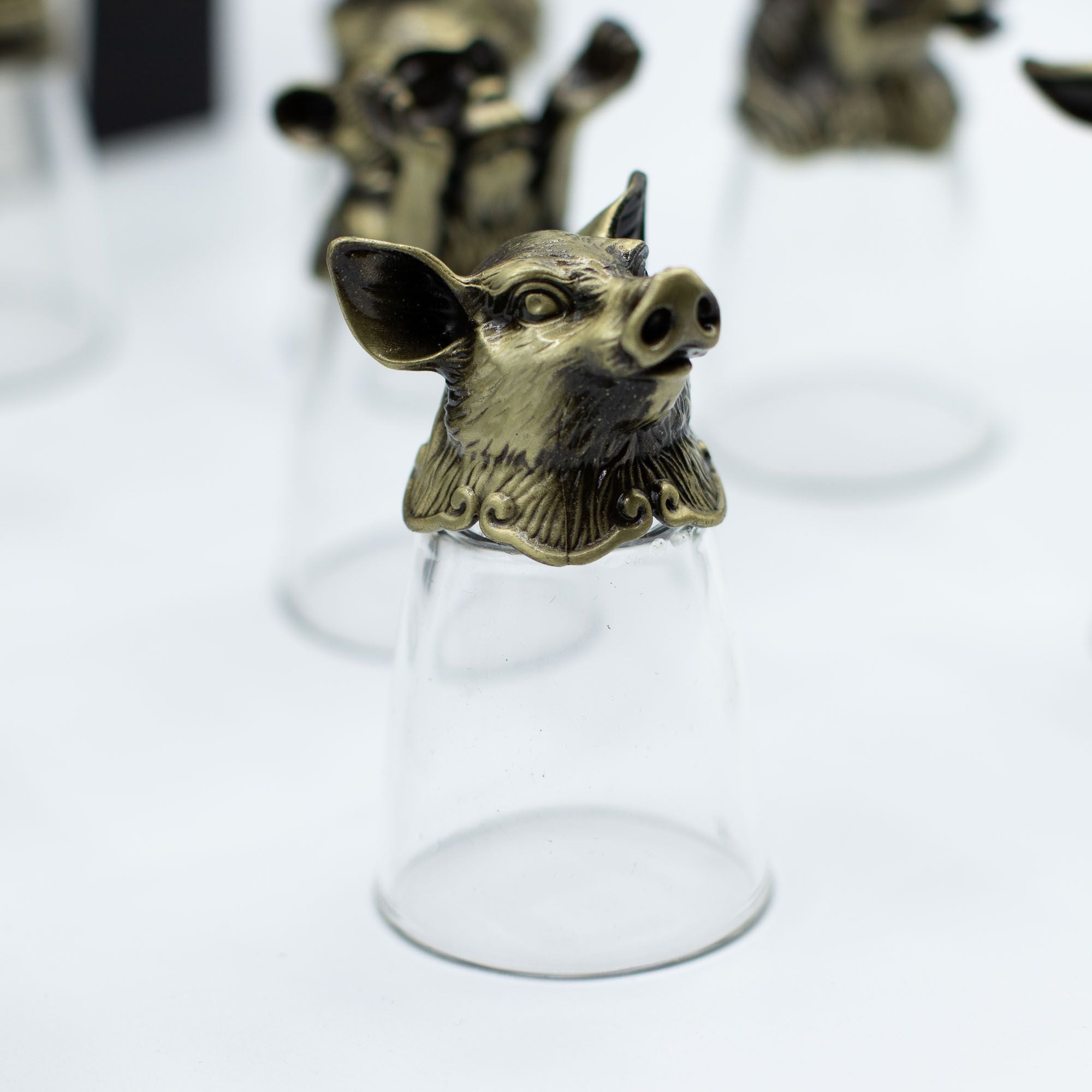 Un verre à shot en bronze antique illustrant un cochon, partie du lot de 12 Bottom Up Shot Glasses (25ml). Idéal pour les accessoires de bar, ce verres à shot de 25 ml combine praticité et éléments du zodiaque chinois. Un coffret cadeau unique qui séduira les amateurs d'arts de la table.