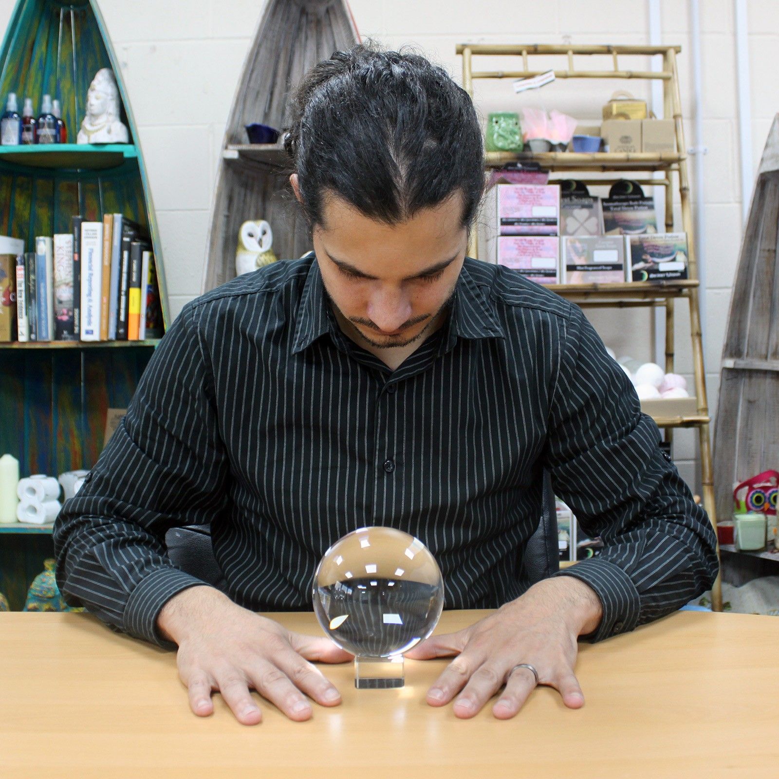 Une personne en train de consulter une boule de cristal sur support de 130 mm, symbole d'accessoire spirituel et d'objet de divination, parfait pour un autel ésotérique ou une décoration mystique. Cette boule de cristal est un bel élément décoratif apportant une ambiance spirituelle et ésotérique.