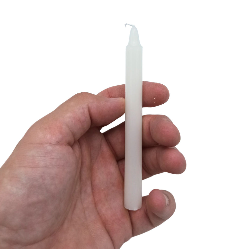 Bougies Manifest Magic (lot de 12) - Ivoire - Protection, montrant une bougie tenue à la main, parfaite pour transformer votre espace en un havre de sérénité et d'harmonie, assurant jusqu'à 90 minutes de combustion, conçue pour les pratiques spirituelles.