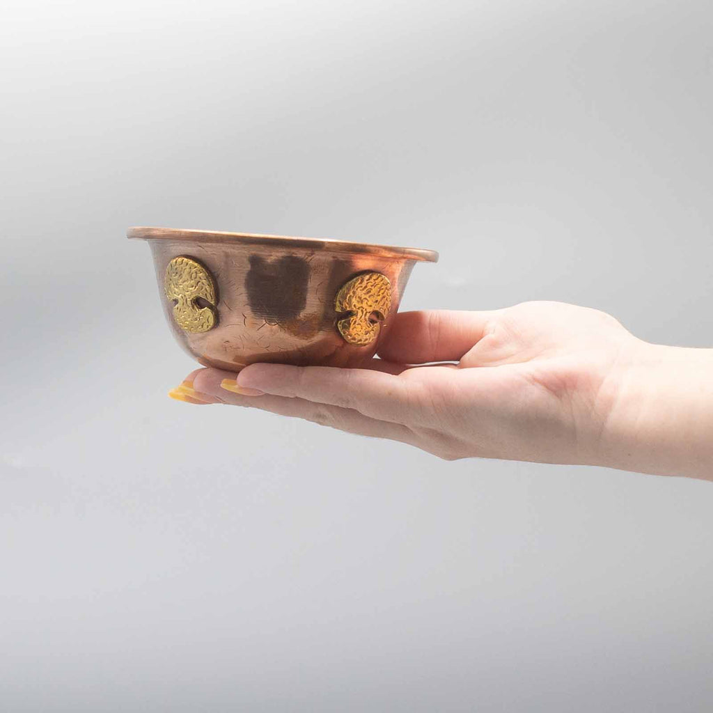 Main tenant la Coupe Rituelle en Cuivre avec Arbre de Vie, montrant sa légèreté et sa taille conviviale. Cette coupe d’offrande en cuivre antique fait un excellent accessoire d’autel pour vos pratiques ésotériques et spirituelles.