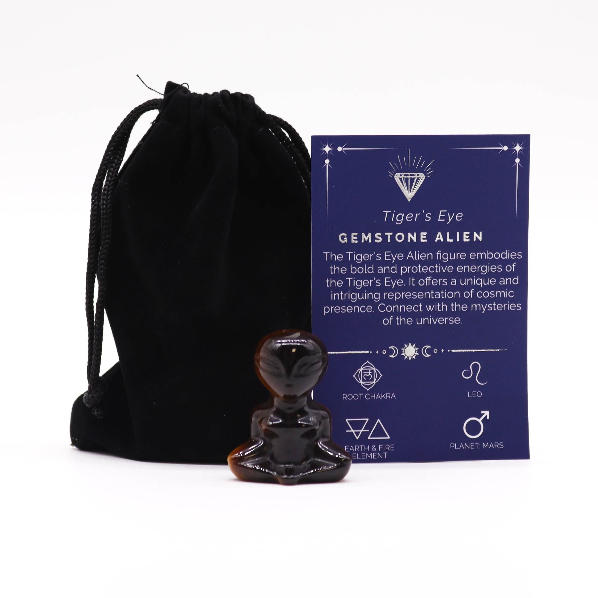 Sculpture D’Alien En Oeil De Tigre en cornaline, représentant une figurine alien, entourée d'une pochette en velours noir et d'une carte explicative sur l'énergie protectrice de l'œil de tigre. Cette figurine, en pierre naturelle, constitue une décoration mystique et un minéral de collection parfait pour ceux qui s'intéressent à la lithothérapie et à la protection énergétique, tout en étant un cadeau original. Découvre cette sculpture alien qui émane des énergies du chakra racine.