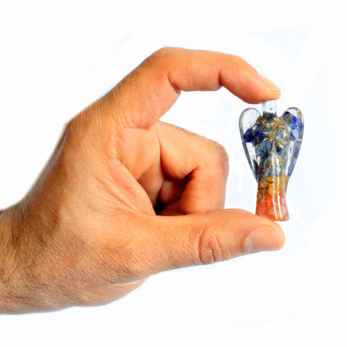 Ange en orgonite avec éclats de pierres et cuivre – 50 mm, tenu dans une main pour montrer sa taille pratique et son design élégant. Cet ange spirituel en orgonite est idéal pour enrichir un autel spirituel ou servir de cadeau spirituel. Sa fabrication en orgonite artisanale, mêlant cuivre et éclats de pierres, en fait un élément de décoration spirituelle et ésotérique unique dans n'importe quel intérieur.