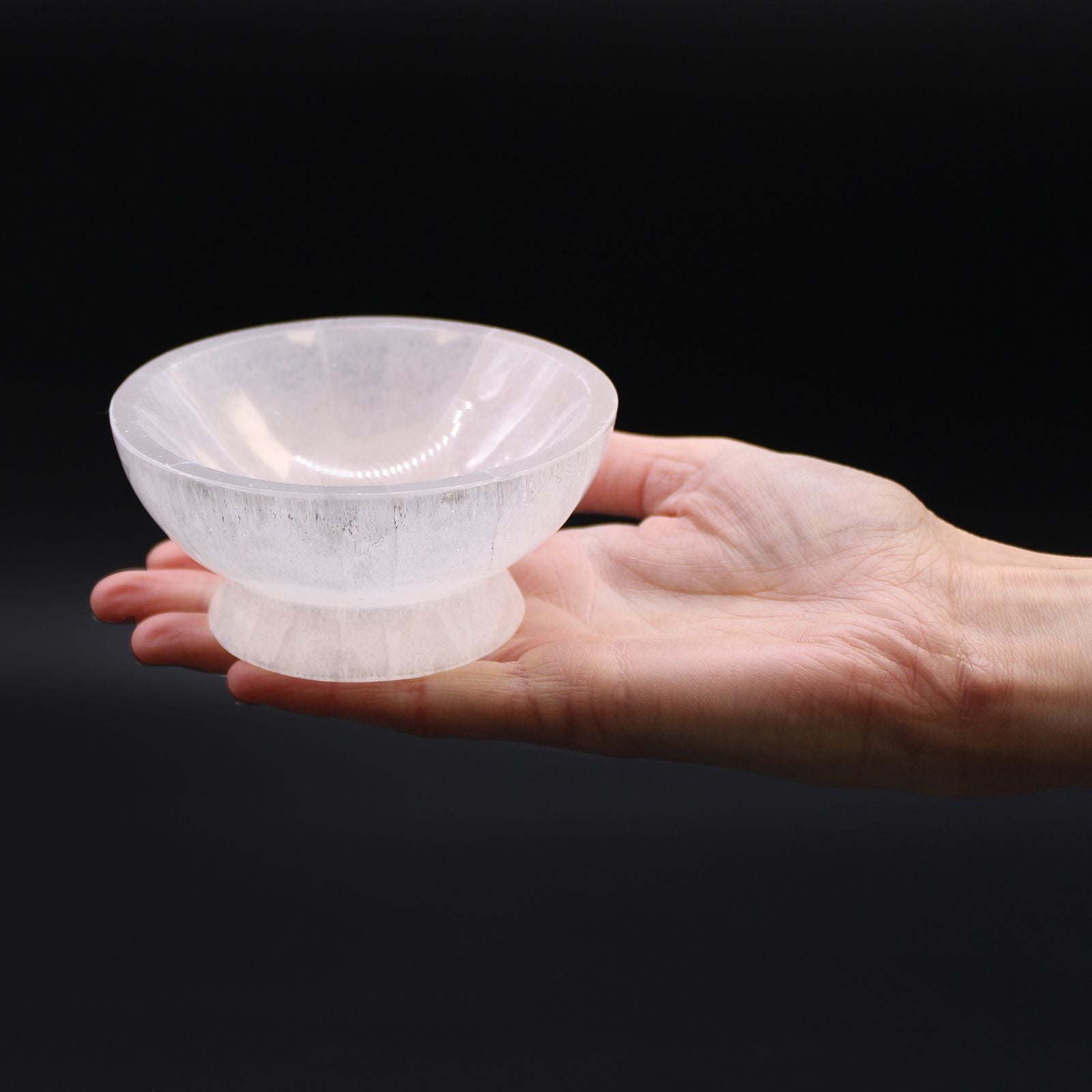 Bol rituel en sélénite 10 cm - Lithothérapie et objets spirituels, tenant dans la main, illustrant son utilisation pour accueillir des objets spirituels, bijoux ou cristaux sur un autel. Ce bol sélénite est une belle addition à toute décoration bohème, spirituelle et ésotérique, apportant une énergie de purification.